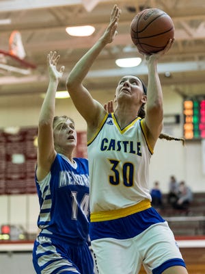 Castle's Jessica Nunge (30) makes a layup as Memorial’s Grace Lensing (14) guards her during the SIAC Tournament Championship match at Harrison High School in Evansville, Ind., Saturday, Jan. 20, 2018. The Knights defeated the Tigers, 41-32, to win their first SIAC tournament title since 2013.
