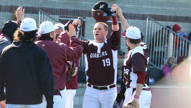 Eric Elkus of the Earlham College baseball team is congratulated by his teammates.