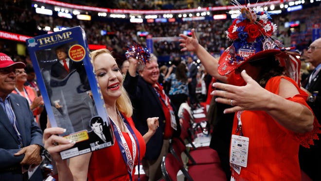 Florida delegates Dana Dougherty, left, holding a Donald Trump doll and Kat Gates Skipper dance before the start of the third day session of the Republican National Convention in Cleveland, Wednesday, July 20, 2016. (AP Photo/Mary Altaffer)