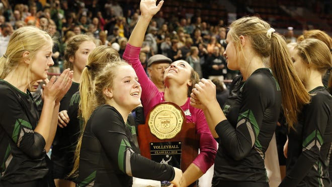 Fossil Ridge senior Lauren Rice, center, looks to sky with tears in her eyes as she holds the 5A State Championship trophy, Nov. 12 at the Denver Coliseum. Fossil Ridge defeated Mountain Vista 3-2.