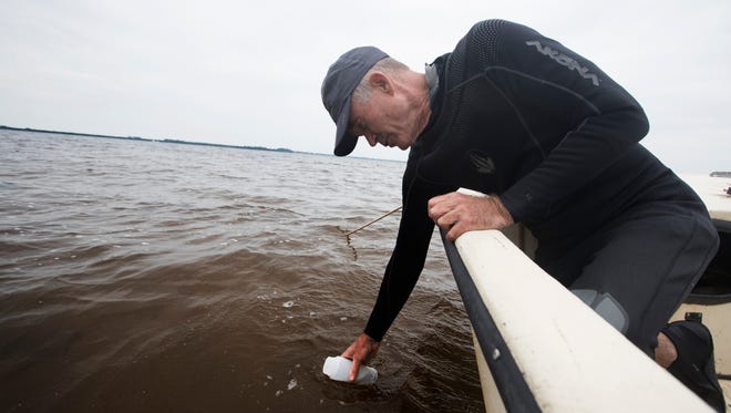 Rick Bartleson, a research scientist for the Sanibel Captiva Conservation Foundation pulls a water sample from the Caloosahatchee River that will be tested for red tide.