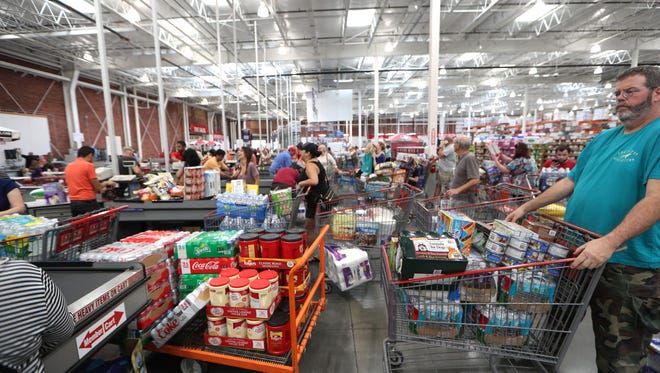 Shoppers fill the checkout lines at Costco, where the store had sold out on batteries, bottled water and generators before noon on Tuesday. Costco representatives said they would have more supplies shipped to the store in the coming days before Hurricane Irma hits the state of Florida. 