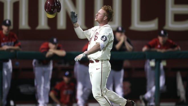 FSU’s Jonathan Foster flips off his helmet as he celebrates his walk-off, 2-run homer to help the Seminoles defeat Louisville 8-7 at Dick Howser Stadium on Friday. 