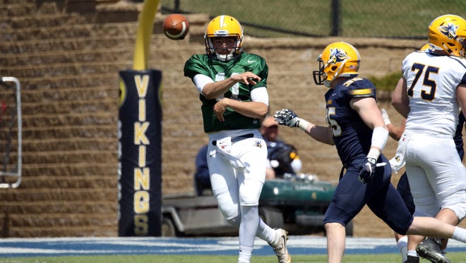 Augustana's Kyle Saddler gets off a pass as Cody Kujawa applies defensive pressure by during Saturday's spring game in Sioux Falls.