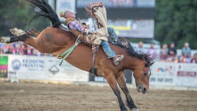 Casey Meroshnekoff of Red Bluff rides bareback in Thursday's performance of the Redding Rodeo.