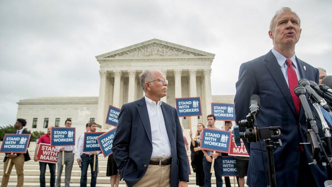 Illinois Gov. Bruce Rauner, right, accompanied by plaintiff Mark Janus, center, speaks outside the Supreme Court after the court rules in a setback for organized labor that states can't force government workers to pay union fees, Wednesday, June 27, 2018, in Washington. (AP Photo/Andrew Harnik)