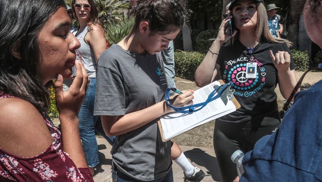 Volunteers register people to vote at the Palm Springs Keep Families Together rally at Frances Stevens Park along North Palm Canyon Drive in Palm Springs. 
