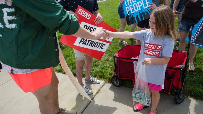 Kate Weissenberger, 6, hands out buttons at the Families Belong Together Rally at Fawick Park in Sioux Falls, S.D. Saturday, June 30, 2018.