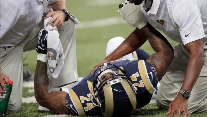 St. Louis Rams running back Isaiah Pead is tended to by trainers after being injured during the first quarter of an NFL preseason football game against the Green Bay Packers on Saturday, in St. Louis.