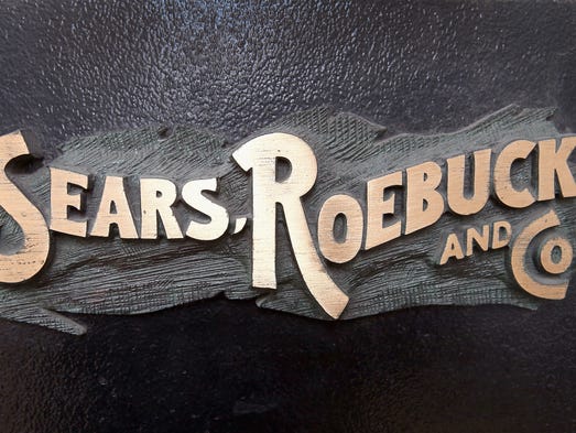 A bronze plaque hangs near the entrance of Sears' flagship