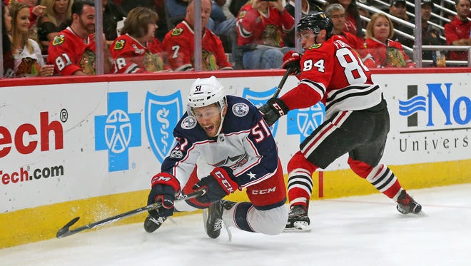 Chicago Blackhawks center Alexandre Fortin (84) is called for a tripping penalty against Columbus Blue Jackets defenseman Jacob Graves (51) during the third period at the United Center.