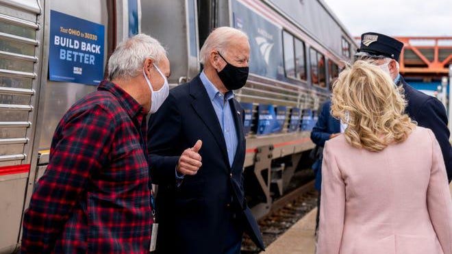 Democratic presidential nominee Joe Biden gives a thumbs up after speaking to his supporters before boarding his train with his wife Jill Biden, right, at Amtrak's Cleveland Lakefront train station on Sept. 30 2020.