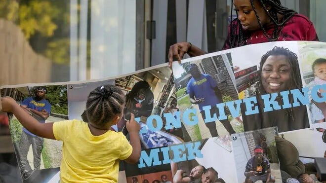 Sabitarry Brice shows off a poster with pictures of her brother, Miekharry Brice, who was killed earlier this year.
