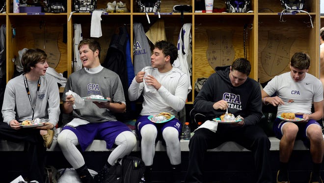 CPA football players enjoy an early Thanksgiving holiday team dinner in the Christ Presbyterian Academy football locker room after practice on Tuesday, Nov. 24, 2015 in Nashville, Tenn. 