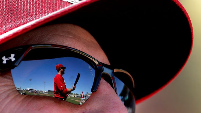 Cincinnati Reds' Brennan Boesch is reflected in manager Bryan Price's sunglasses as he warms up on deck during the second inning of a spring training baseball game against the Kansas City Royals Saturday, March 7, 2015, in Surprise, Ariz.