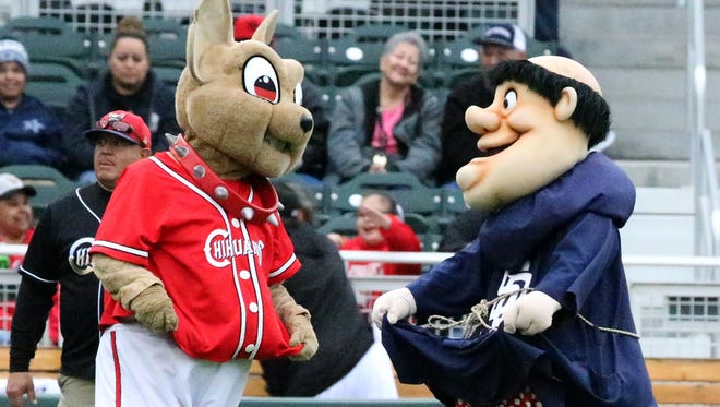 Chico, the El Paso Chihuahuas mascot and the San Diego Padres mascot frolic on the field at the start of an exhibition game Monday. 