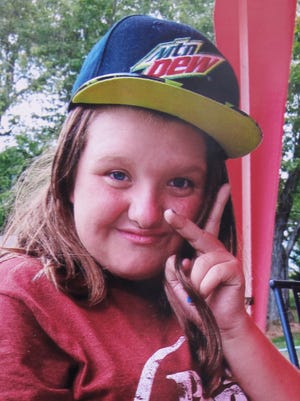 In this 2015 photo provided by Tammy Weeks, her daughter, Nicole Lovell, flashes a peace sign in Blacksburg, Va. The 13-year-old girl was found dead just across the state line in Surry County, N.C., and two Virginia Tech students are charged in the case.