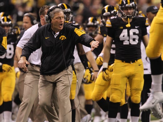 Iowa head coach Kirk Ferentz high-five's players after