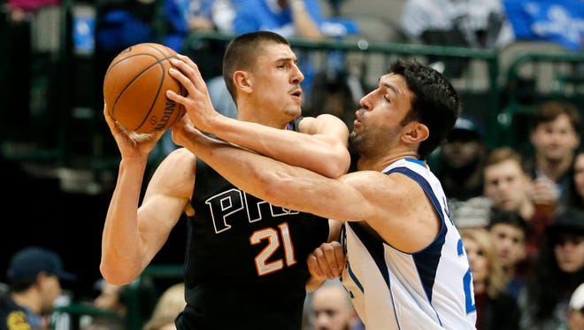Phoenix Suns center Alex Len, left, attempts to get to the basket as Dallas Mavericks center Zaza Pachulia, right, defends in the first half of an NBA basketball game, Monday, Dec. 14, 2015, in Dallas.