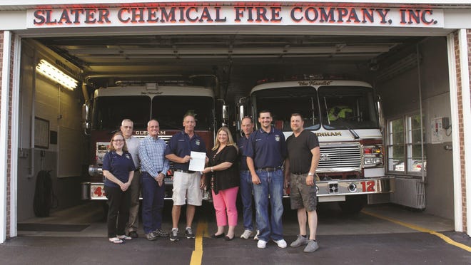 Madonna Smith of Chevron presents James Pavelock of the Glenham Fire District with a $5,000 check. From left to right: Vicky Steele, John Steele, Mark Hendrickson, James Pavelock, Madonna Smith, Doug Zukowski, Tim Strang and Dave Dross.