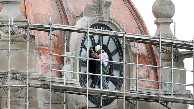 Repair work has begun on the Brown County Courthouse roof. A worker under the general contractor, Structural Preservations Systems, LLC,  enters the north facing clock of the historic courthouse in downtown Green Bay.