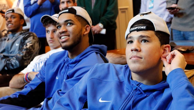 Karl-Anthony Towns, left, and Devin Booker along with other members of Kentucky's men's basketball team watch the NCAA college basketball tournament selection show at the home of head coach John Calipari in Lexington, Ky. March 15, 2015