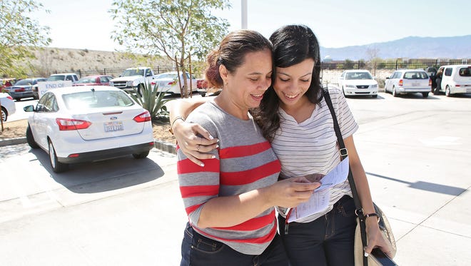 Yolanda Lozano gets a hug from her daughter Elizabeth Encino after passing her driving test at the DMV in Palm Desert, April 8, 2015.