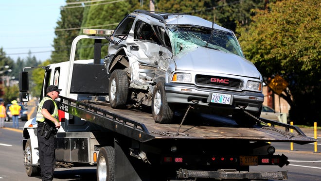 An SUV that was carrying a toddler sits on the back of a wrecker after being involved in a crash with a pickup truck on Kuebler Boulevard at Sunnyside Road SE, Thursday, Oct. 1, 2015, in Salem, Ore.