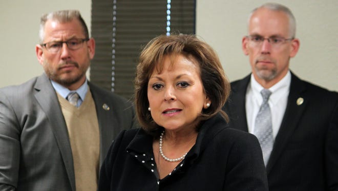This Tuesday, Jan. 5, 2016 photo, Gov. Susana Martinez, center, unveils her budget priorities for the upcoming legislative session as Corrections Secretary Greg Marcantel, left, and Public Safety Secretary Greg Fouratt stand behind her during a news conference in Albuquerque, N.M. New Mexico officials are revising revenue expectations downward as state lawmakers confront state budget shortfalls reminiscent of the 2008 recession. Members of the Legislative Finance Committee that drafts the state budget are meeting Wednesday, Aug. 24, 2016, in the town of Red River. Martinez says she plans to reconvene lawmakers and has recommended all state agencies reduce spending by 5 percent.