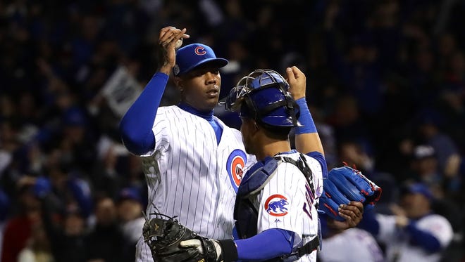 Aroldis Chapman #54 (L) and Willson Contreras #40 of the Chicago Cubs celebrate after beating the Cleveland Indians 3-2 in Game Five of the 2016 World Series at Wrigley Field on October 30, 2016 in Chicago, Illinois.