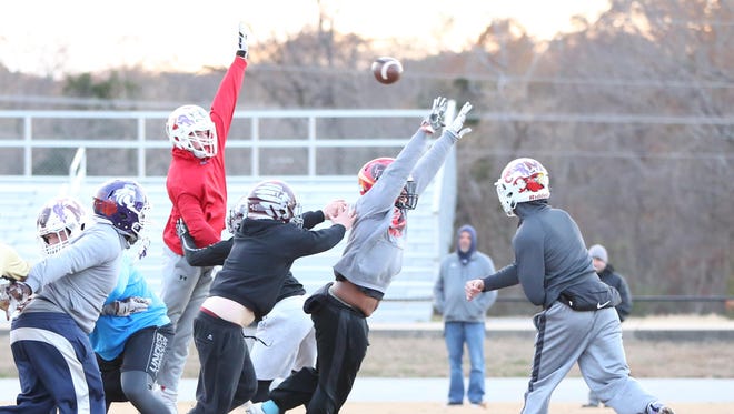 West Tennessee All Star Football player Rhett Peel, University School of Jackson, seen here in red, leaps to try to block the pass from the offensive team.