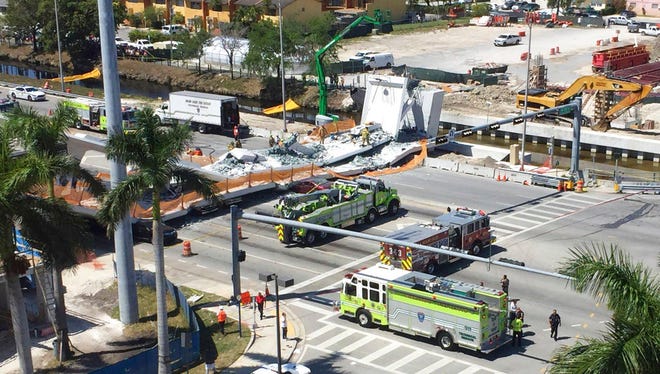 Emergency personnel responds to a collapsed pedestrian bridge connecting Florida International University on Thursday, March 15, 2018 in the Miami area.  The  brand-new pedestrian bridge collapsed onto a highway crushing at least five vehicles. Several people were seen being loaded into ambulances and authorities said they were searching for people. (Roberto Koltun/The Miami Herald via AP)