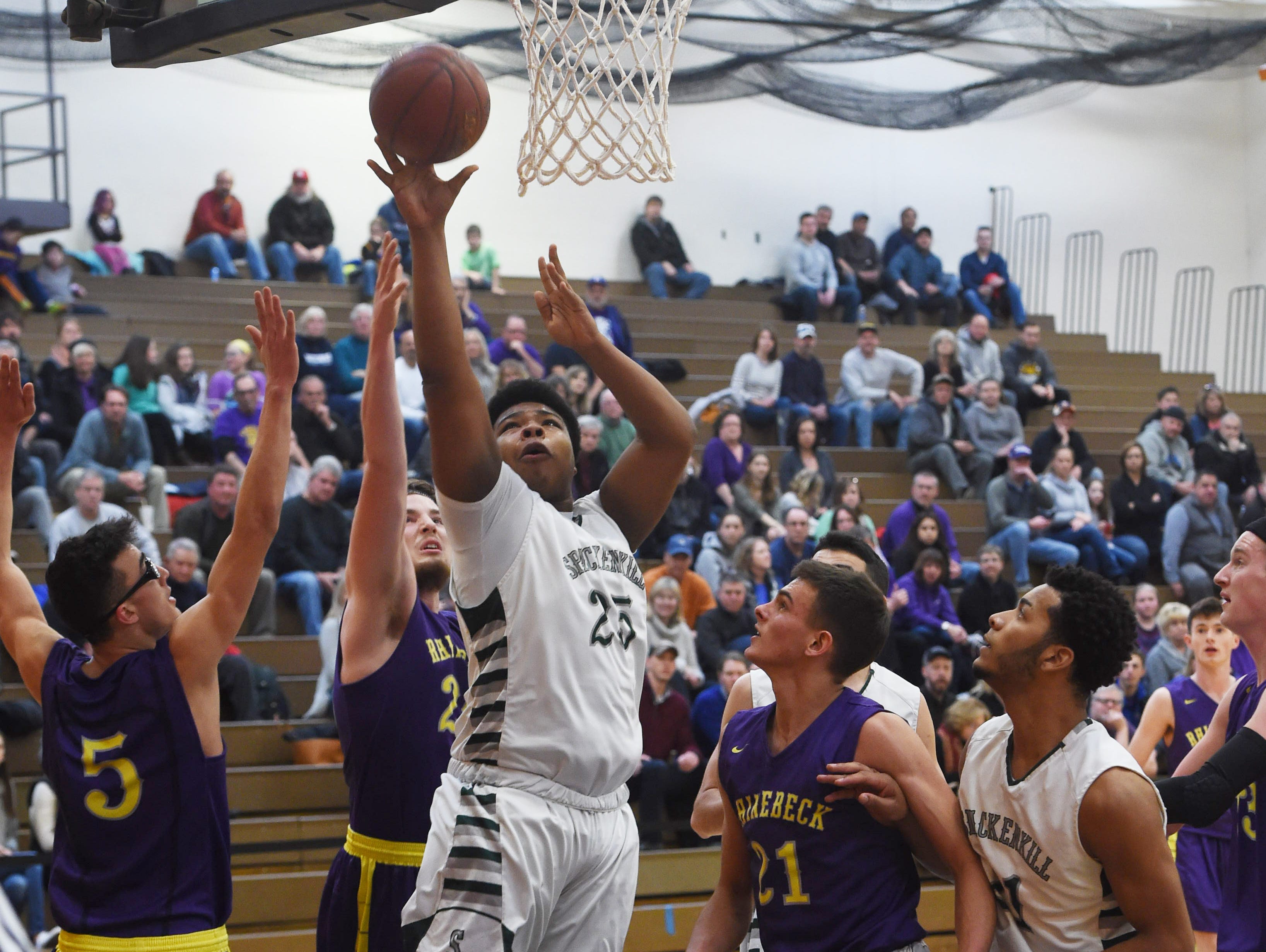Spackenkill's Kyiev Bennermon, center, goes for a layup during Saturday's Section 9 championship game against Rhinebeck at SUNY Orange in Middletown.