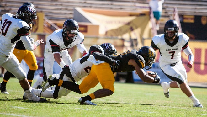 Saguaro's Christian Kirk is tackled in the first quarter of the Division III state championship game on Saturday, Nov. 29, 2014, at Sun Devil Stadium in Tempe, Ariz.