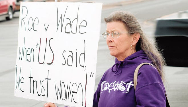 In this 2013 file photo, Denise Lang carries a sign commemorating the anniversary of the Supreme Court's ruling on Roe V. Wade.