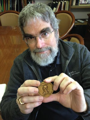 In a Nov. 2014 photo at the Cranbrook Institute of Science, Vatican astronomer and Jesuit Brother Guy Consolmagno, , displays the Carl Sagan Medal he was awarded in 2014 for his distinguished work in explaining the planetary sciences to the public.