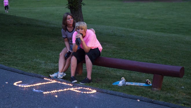 Tina Evers, left, sits with her daughter Rachel Evers, 15, after the vigil for Julian Parrott at Gypsy Hill Park on Monday, May 12, 2014.
