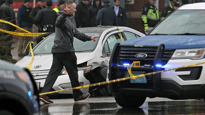 In this Feb. 7, photo, police investigate the scene of a shooting at the intersection of Rt. 9 and Hammond Street in Brookline, that started near Brigham and Women's Hospital in Boston. Police shot and killed the driver, Juston Root, following a confrontation and car chase. Root's family filed a wrongful death lawsuit on Monday, Aug. 10.
