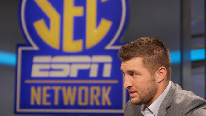 Tim Tebow answers a question during a interview on the set of ESPN's new SEC Network in Charlotte, N.C., Wednesday, Aug. 6, 2014. Tebow has a new job as a commentator for the SEC Network, but is still looking for work in the NFL as a quarterback. (AP Photo/Chuck Burton)