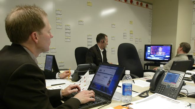 Cleveland Browns' senior vice president and general manager Phil Savage, left, works in the "war room" with college area scout Jim Jauch, center and research and development scout Rich Long on NFL Draft day at The Cleveland Browns training center