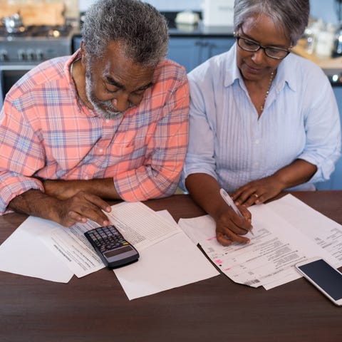 Two adults using calculators and reviewing paperwo