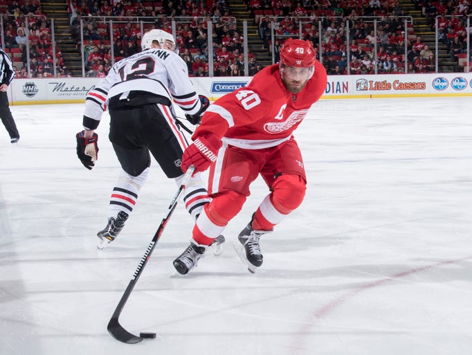Detroit left wing Henrik Zetterberg scoops up the puck