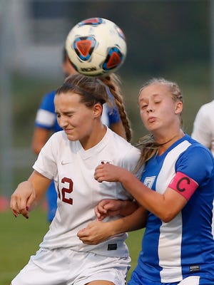 Kassidy Crowe of McCutcheon gets a head on the ball in front of Jenna Robertson of Kokomo in the first half of the girls soccer sectional Thursday, October 5, 2017, at Harrison High School.