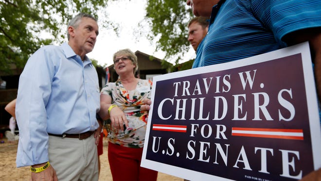 Travis Childers, left, Democratic nominee for the U.S. Senate seat held by incumbent Republican Senator Thad Cochran speaks with supporters following his address at the Neshoba County Fair in Philadelphia, Miss., Thursday, July 31, 2014. The fair is a traditional gathering place for politicians, area residents, business leaders, voters and families.