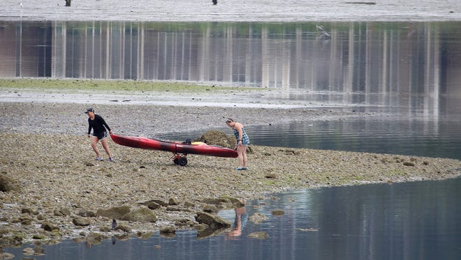 Sindy Saya, left, and Ingrid Pulhug both from Silverdale, pull their kayak off the beach near Silverdale Waterfront Park on Friday. The Port of Silverdale wants to make its waterfront more inviting to boaters of all stripes.