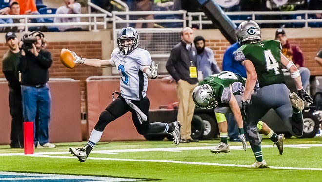 Tony Palmer (left) of Lansing Catholic scampers into the endzone past Grand Rapids West Catholic defenders for a touchdown to give Lansing Catholic a 19-17 lead midway through the 4th quarter of their Division 5 state championship game Saturday November 29, 2014 at Ford Field in Detroit.  KEVIN W. FOWLER PHOTO