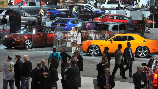 Media members swarm over the floor at Cobo Center during the 2014 North American International Auto Show.