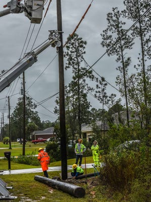 Gulf Power crews restore power to a home in Navarre Beach on Sunday, Oct. 8, 2017.
