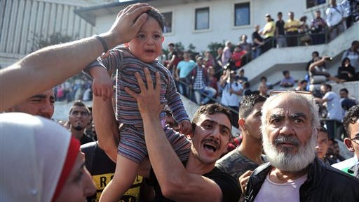 A Syrian refugee argues with Turkish security Sept. 15 as hundreds of people trying to reach Europe have gathered at a central bus station in Istanbul.