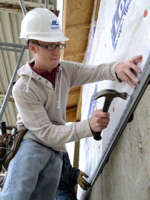 Nathan Taulbee, a senior at Canal Winchester High School, works on a mock house Tuesday at the Fairfield Career Center in Carroll. Taulbee is a student in the construction technology program at the school.